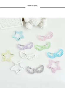 Detalle de colgantes de estrellas y alas de acrílico brillante en colores pastel macaron