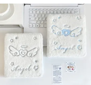 Detalle del archivador de fotos A6 de felpa blanca con bordado de alas de ángel plateadas