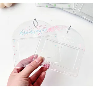 Primo piano dei porta tessere in PVC glitterato con motivo a fiori di ciliegio e catenine