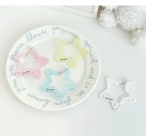 Primer plano de colgantes de mosquetón de estrella acrílica con purpurina en varios colores