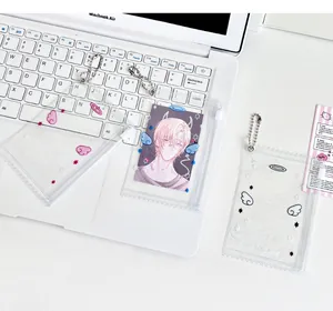 Porte-carte en PVC transparent avec ailes d'ange et chaîne en métal sur un clavier