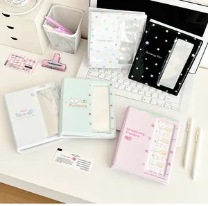 Flat lay of multiple colorful PVC photo albums with star and strawberry themes on a desk