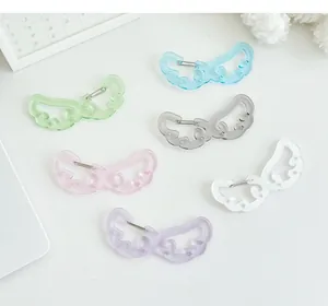 Detalle de llaveros de alas con purpurina de colores, estrellas en relieve y acrílico