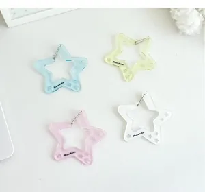 Detalle de llaveros de acrílico con forma de estrella y purpurina en varios colores