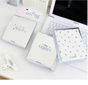 Tre simpatici raccoglitori di carte bianchi con motivi di stelle e gatti su una scrivania