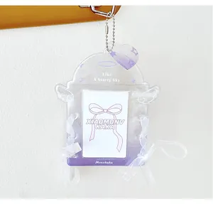 Macro detail of purple glitter acrylic photocard holder with lace ribbon and angel wings