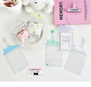 Detalle de portatarjetas de PVC transparente con forma de casa y cadenas de colores
