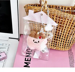 Primer plano del colgante gato de peluche rosa en estuche transparente con forma de casa