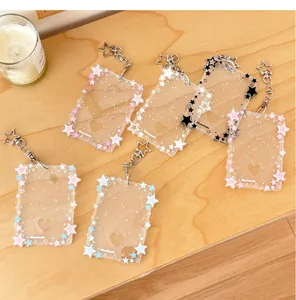 Detailed view of six glitter acrylic photocard holders with star keychains on wood table