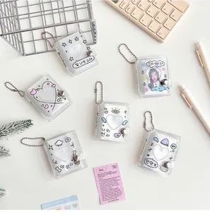 Detailed view of mini glitter photo albums with heart and star patterns and ball chains