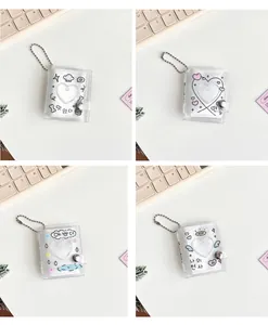 Detailed view of four glittery mini photo albums with heart cutouts and bead chains