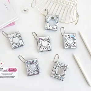 Macro shot of silver mini heart-hollow photocard albums with decorative star and angel prints