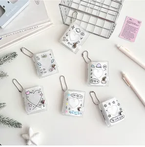 Detailed view of mini glitter photo albums with heart windows and metal ball chains