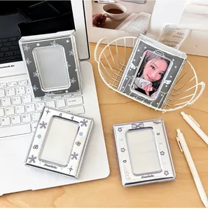 Close-up of silver and black photocard holders with star, heart, and wing patterns