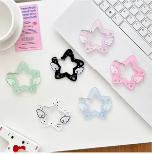 Makroaufnahme bunter sternförmiger Acryl-Anhänger mit Flügeln und MonstaX-Logo