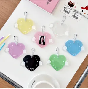 Primer plano de portatarjetas de acrílico con forma de corazón, alas y cadenas de bolas
