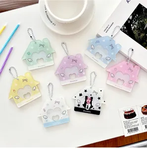 Détail de porte-cartes en acrylique colorés en forme de maison avec découpe en cœur