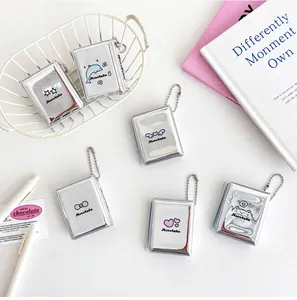 Detail view of mini silver card holders with cute embossed animal icons and metal chains