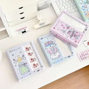 Cute cartoon kpop card binders in pastel blue and purple on a white desk setup