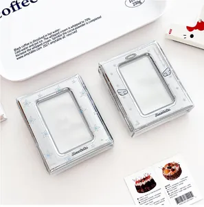 Close-up of silver mini photo albums featuring blue stars and angel wings designs