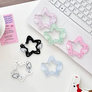 Sternförmige Acryl-Ohrringe mit Flügeln in sechs Pastellfarben auf weißer Tastatur