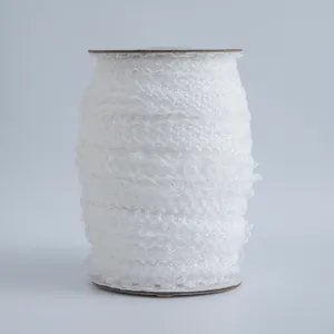 Dettaglio di pizzo elastico bianco da 1,5 cm su bobina di cartone per decorazioni DIY