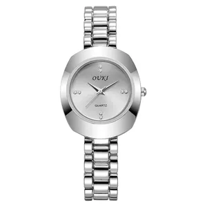Macro detail of silver quartz watch featuring sunburst dial and rhinestone markers