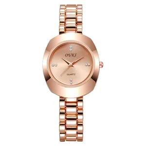Detail of rose gold quartz watch featuring diamond accents and geometric cut-glass case