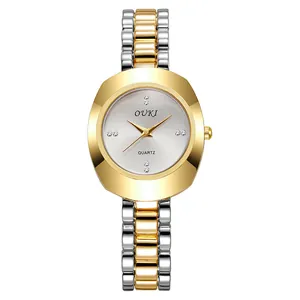 Macro detail of the quartz watch dial with crystal indices and bicolor metal chain band