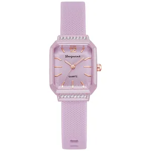 Dettaglio macro orologio al quarzo quadrato viola con castone di diamanti e cinturino