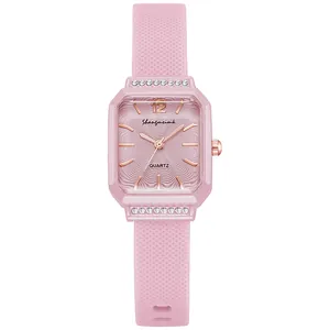 Dettaglio di un orologio al quarzo rosa con lunetta rettangolare diamantata e cinturino