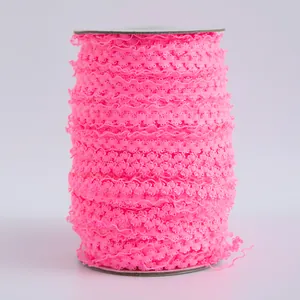 Dettaglio di nastro in pizzo elastico rosa fluo da 1,5cm per decorazioni per bambole