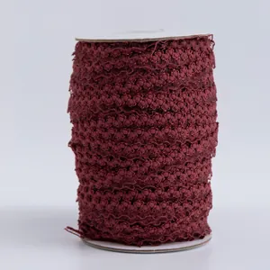Dettaglio di nastro elastico a corona bordeaux da 1,5cm su rocchetto per decorazioni