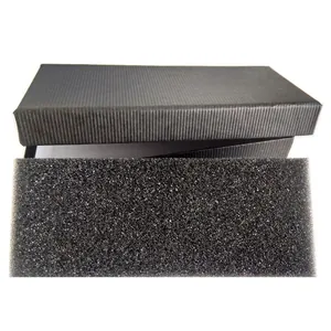 Detalle de caja de regalo negra rectangular con rayas verticales e inserto de espuma