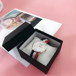 Reloj de cuarzo en oro rosa con correa de nailon a rayas en una caja de regalo negra
