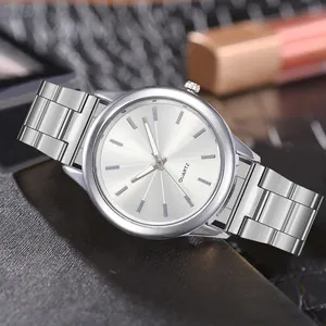 Macro detail of silver quartz watch with polished metal band and sunburst textured dial