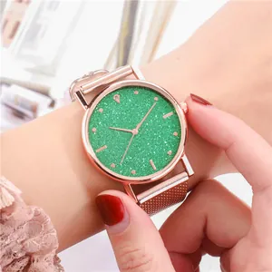 Primer plano de reloj oro rosa con esfera verde oscuro brillante y malla de acero