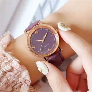 Women's quartz watch with purple leather strap and rose gold case on female wrist