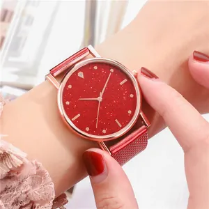 Primer plano de un reloj de cuarzo para mujer con caja de oro rosa y esfera roja brillante