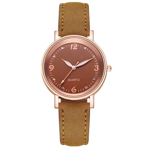 Detailed close-up of brown suede watch strap and rose gold quartz watch face