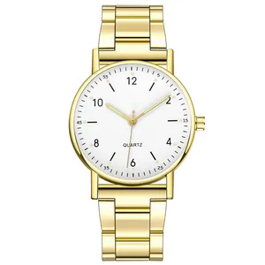 Vista macro de reloj de cuarzo dorado con manecillas luminosas y números arábigos