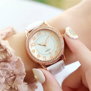 Nahaufnahme der Damen-Quarzuhr mit Kristalllünette und weißem Lederarmband am Handgelenk