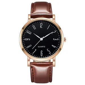 Détail d'une montre à quartz rose doré, cadran noir et bracelet en cuir marron