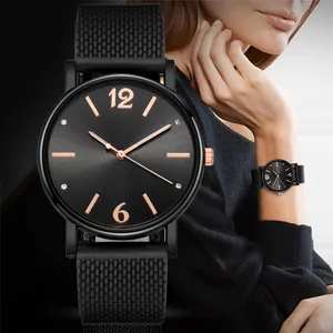 Dettaglio di un orologio al quarzo nero con indici in oro rosa e cinturino mesh
