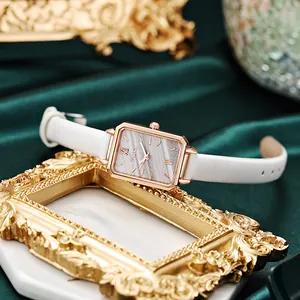 Detail of retro small square watch with rose gold case and marble dial on velvet