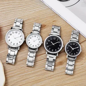 Classic silver steel couple watches with black and white dials on a wood background