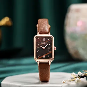 Detail of square rose gold watch with brown wood-grain dial and leather strap