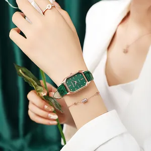Détail de la montre verte rectangulaire élégante avec boîtier doré et parure