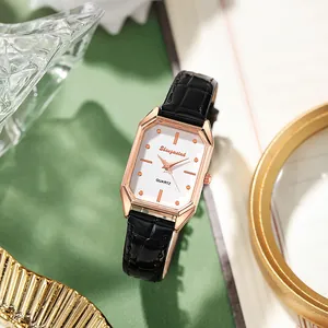 Gros plan d'une montre octogonale en or rose avec cadran blanc et bracelet en cuir