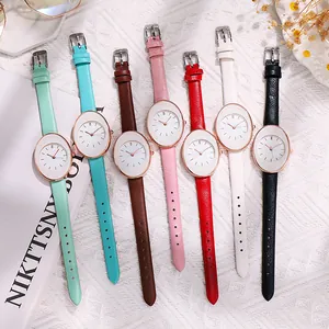 Women's minimalist oval quartz watch set with multiple colored leather straps on fabric